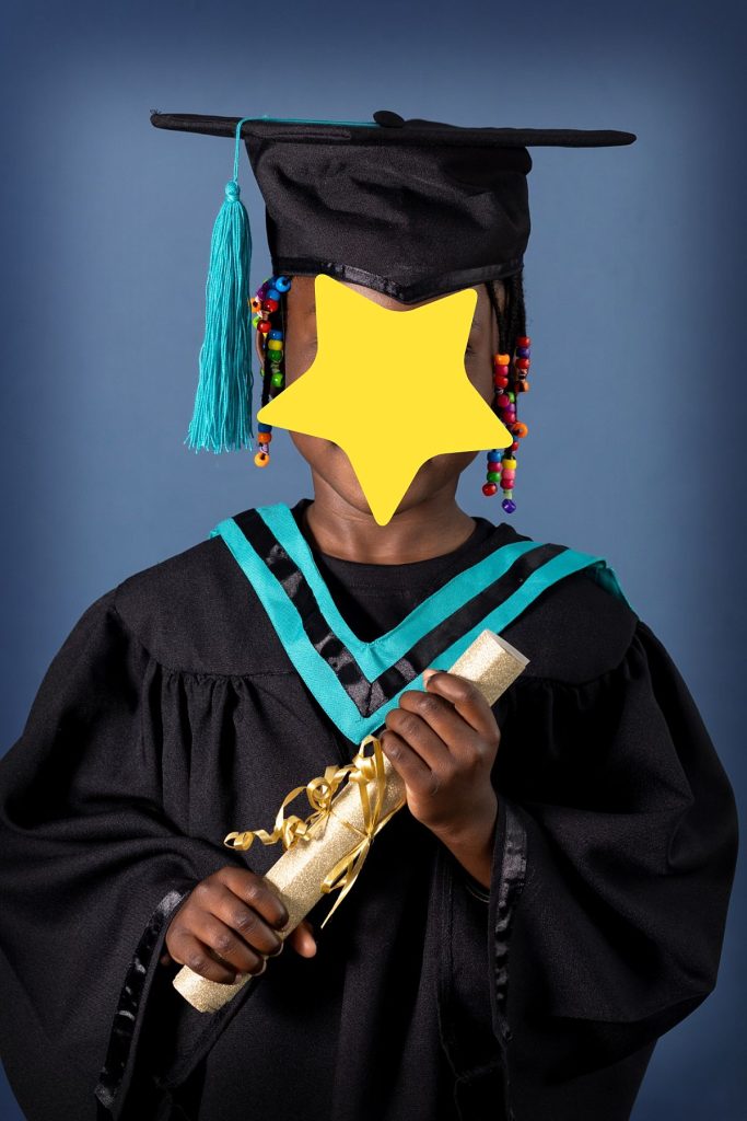 Grade R graduation photo with scroll and hat, with a blue studio background
