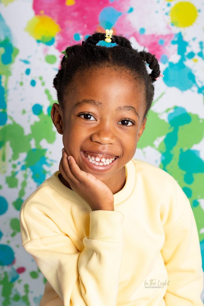 Preschool photo of a girl smiling happily during their annual nursery school photo day in Sandton